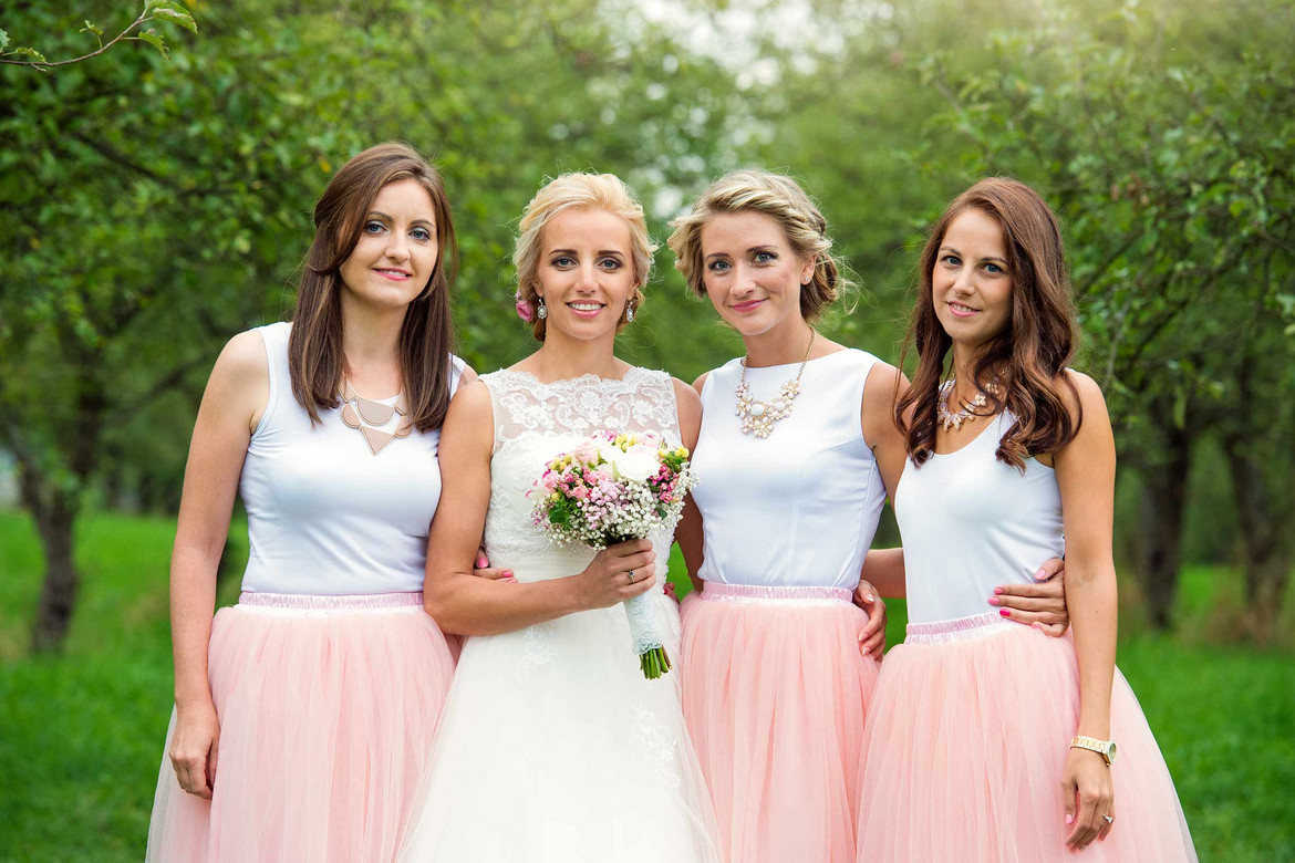 Dresscode bei der Hochzeit. Braut mit drei Brautjungfern mit rosa Röcken
