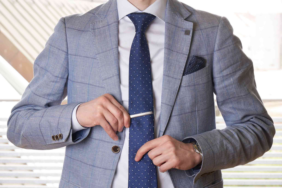 Ein Mann richtet seine Krawattennadel