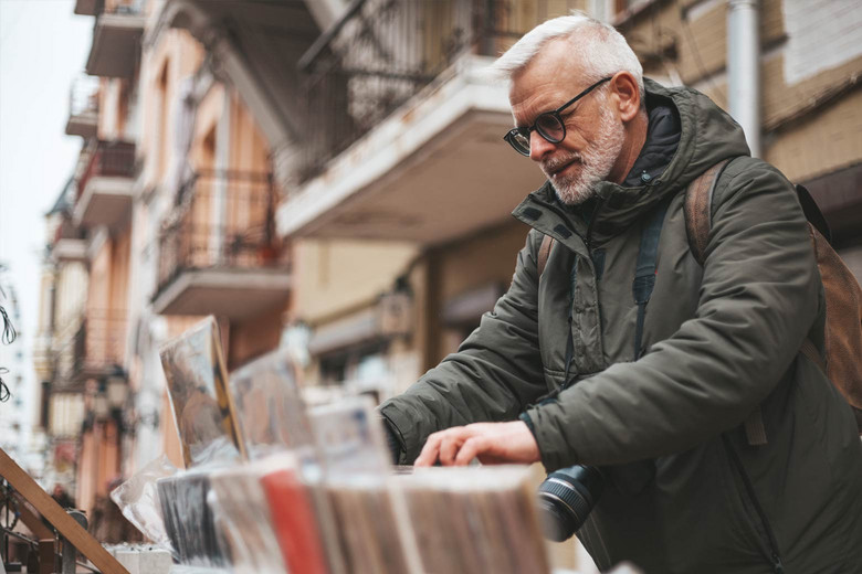 Ein älterer Mann stöbert auf einem Flohmarkt