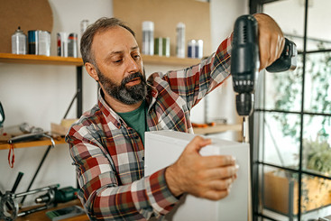 Mann verwendet Akkubohrer