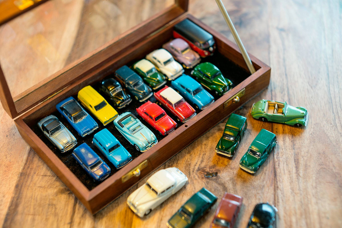 Eine Holzkiste mit einer Sammlung von Modellautos steht auf Holzboden