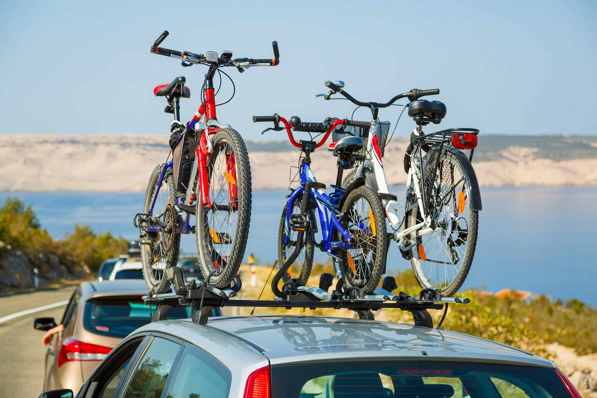 Drei Fahrräder auf Autodach in Urlaubsland