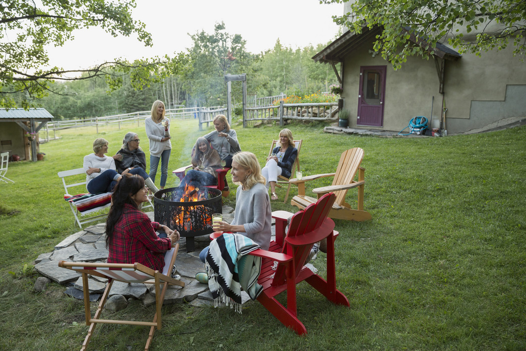 Menschen sitzen um einen Tisch im Garten