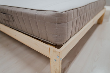 Eine Matratze auf einem simplen Holzbett