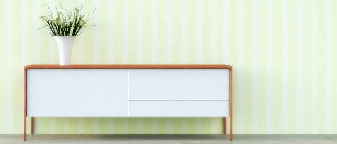 modisches Sideboard in Weiß mit Holzelementen vor einer hellgrünen Wand